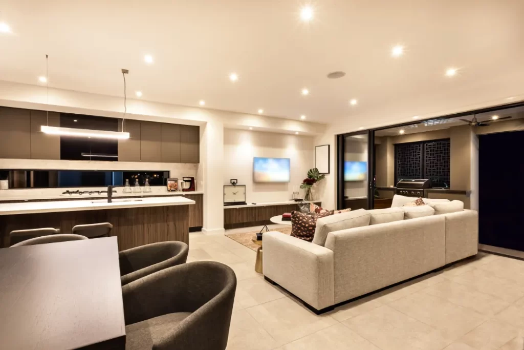 Modern open-plan living and kitchen area with recessed ceiling lighting, professionally installed by electricians in Nambour.
