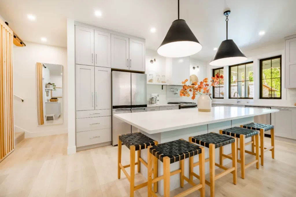 Bright modern kitchen with pendant lighting and recessed ceiling lights, showcasing expert electrical installation by Sunshine Coast electricians.