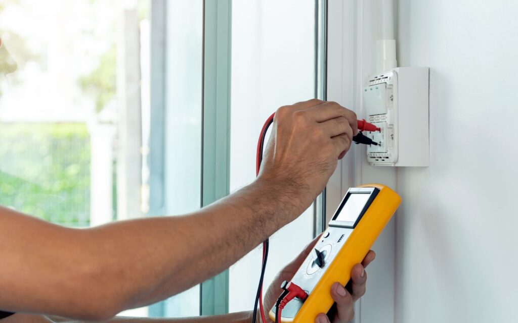 Experienced electrician from Sunshine Coast Electrician repairing and wiring a wall switch with multiple electrical wires
