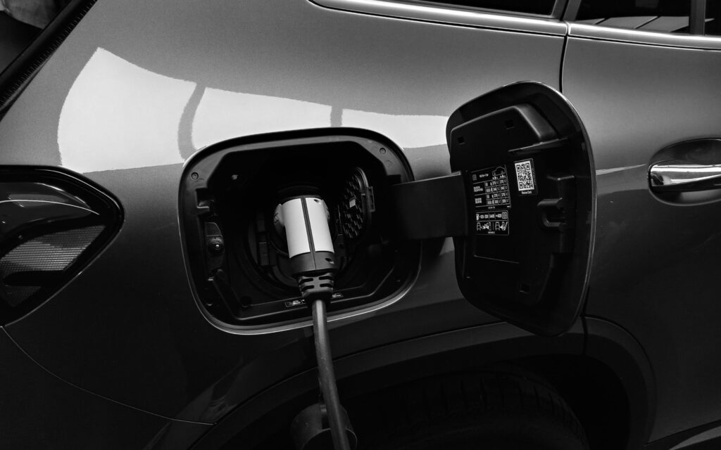 Electric vehicle charging port with connector plugged in on a sleek car – Sunshine Coast EV charger installation by professional electrician