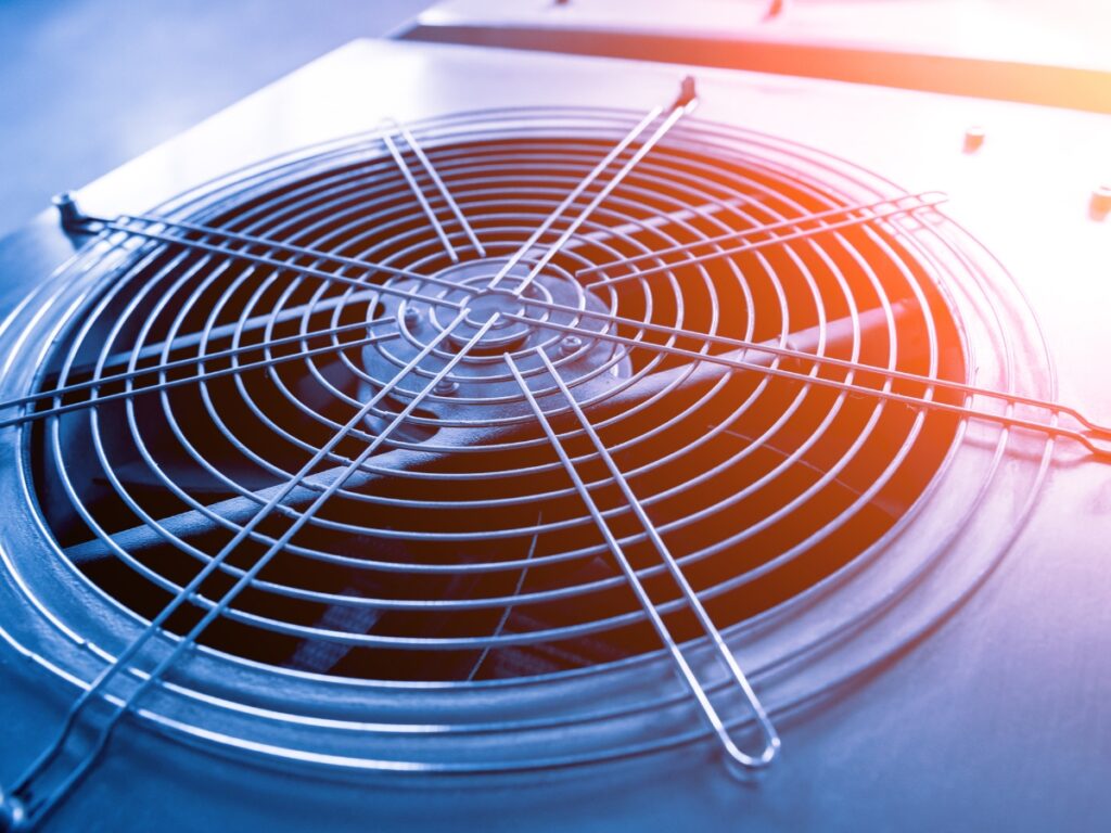 Industrial air conditioning fan component for Sunshine Coast air conditioning installation, featuring energy-efficient air conditioning system with protective wire grille and blue-orange lighting