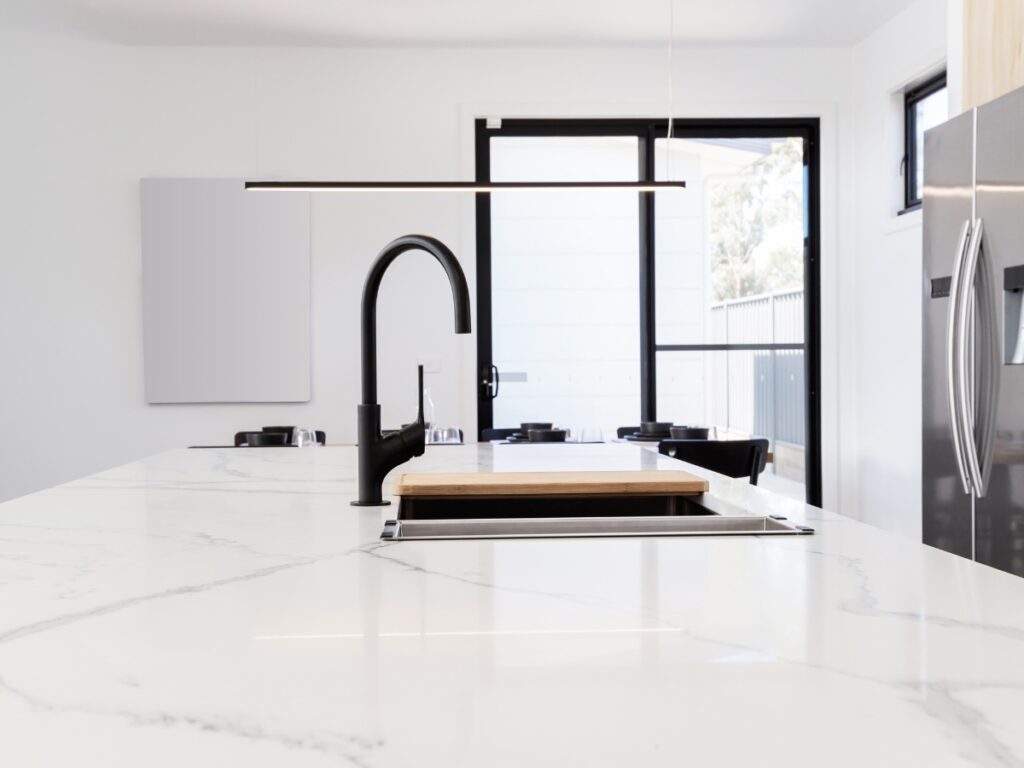 Professional electrical fit-out by Sunshine Coast Electrician featuring modern kitchen with marble island, pendant lighting, and complete kitchen rewiring services for new homes on the Sunshine Coast